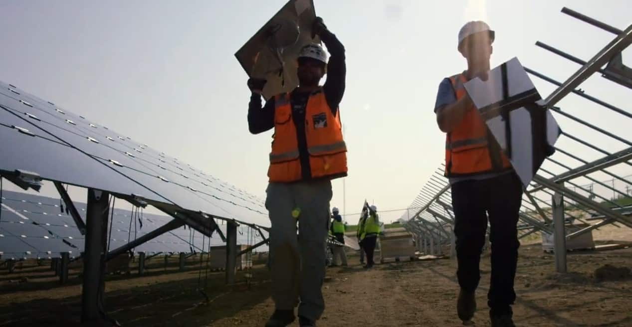 Workers carrying solar panels