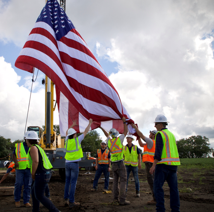Workers raising american flag