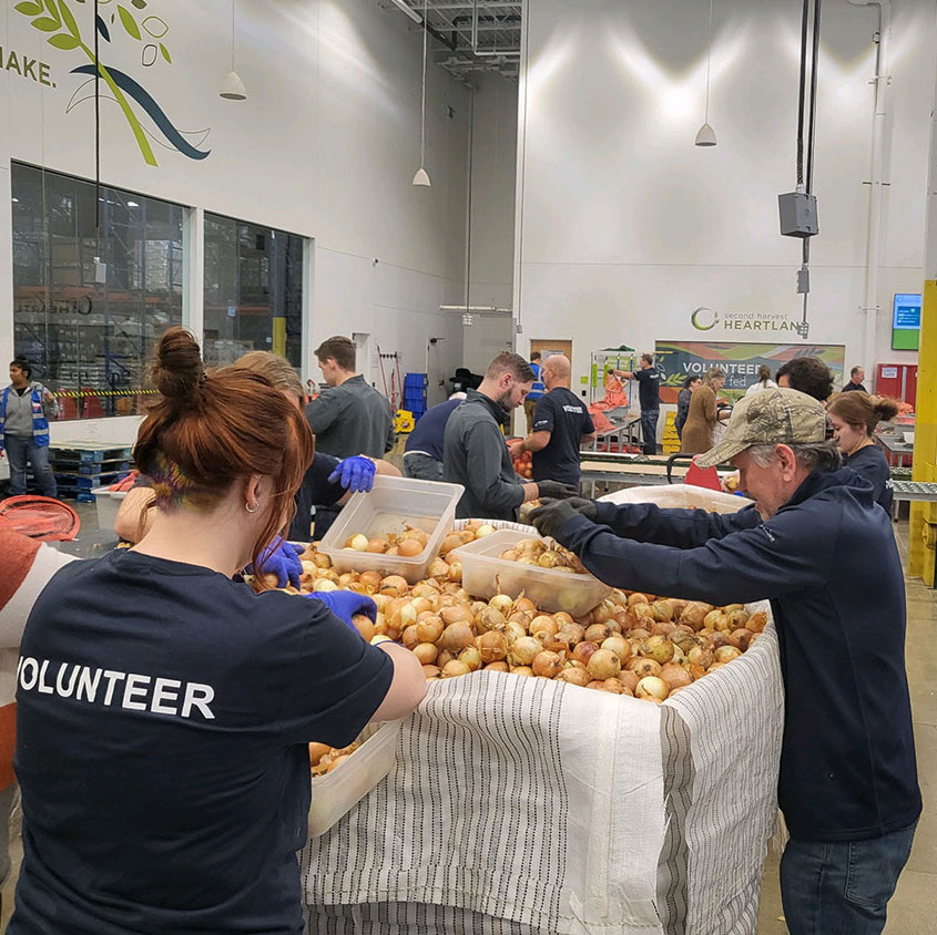 National Grid Renewables team volunteering at Second Harvest Heartland with bin of onions