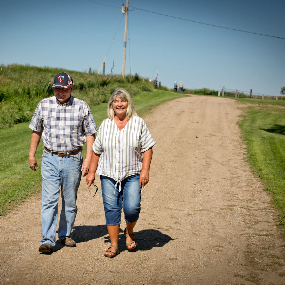 Man and woman walking down rural road