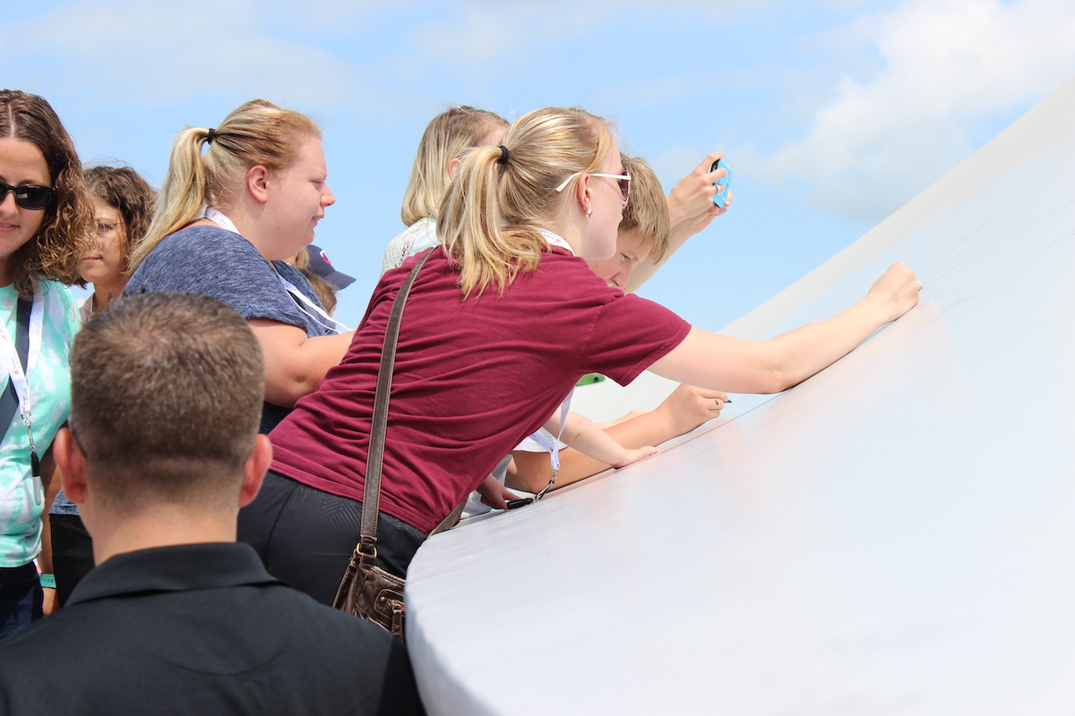 People signing a turbine blade