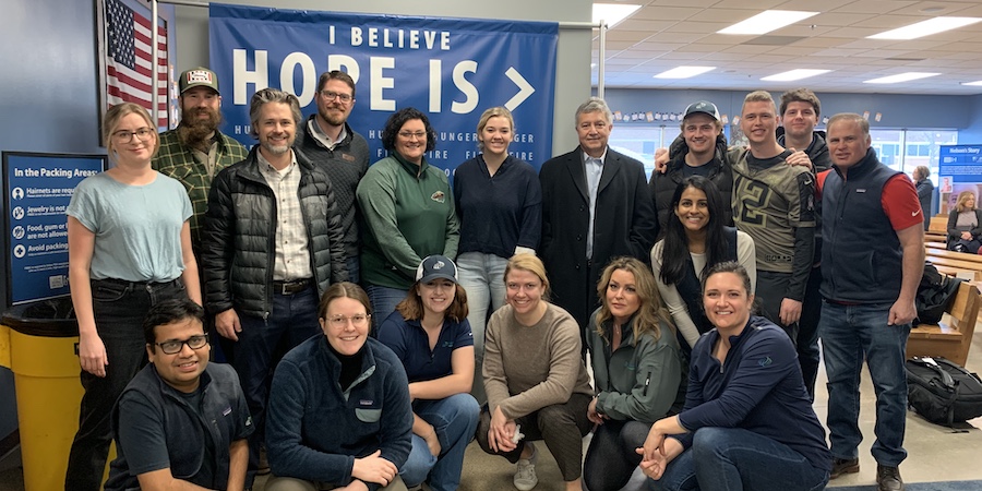 Group of people in front of 'I believe hope is' banner