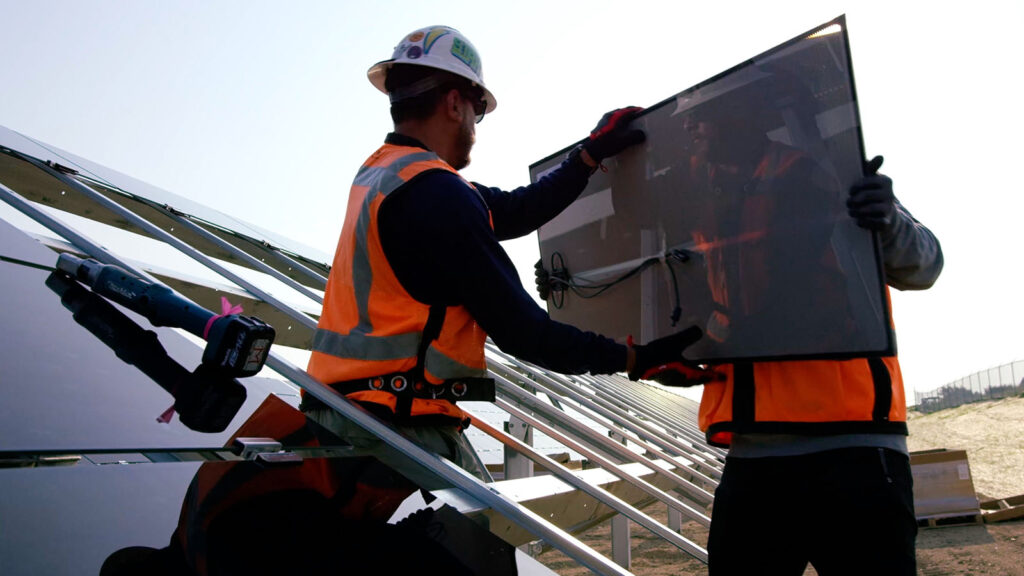 Workers assembling solar panels