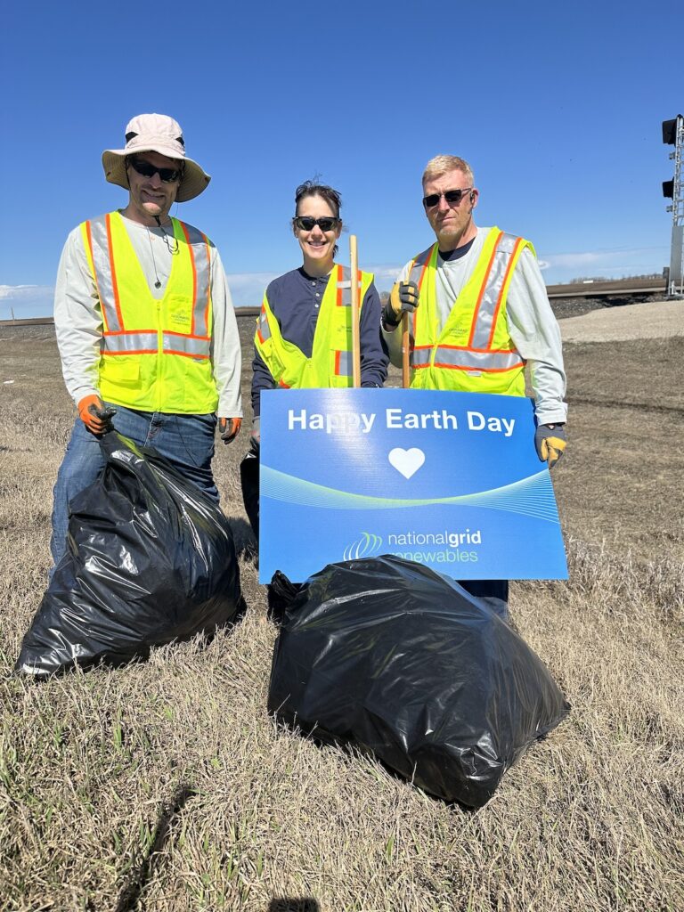 People with Happy Earth Day sign and trash bags