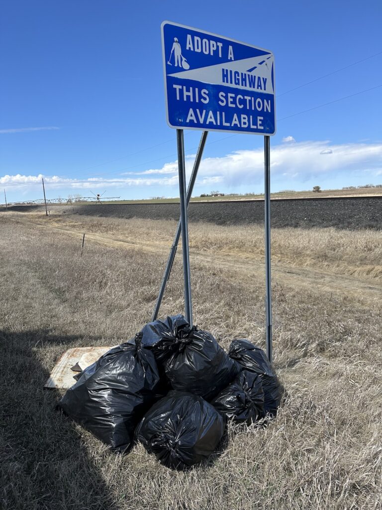 Adopt a Highway sign with trash bags